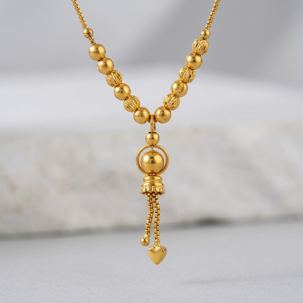 Close-up of gold-tone beaded chain necklace worn by model