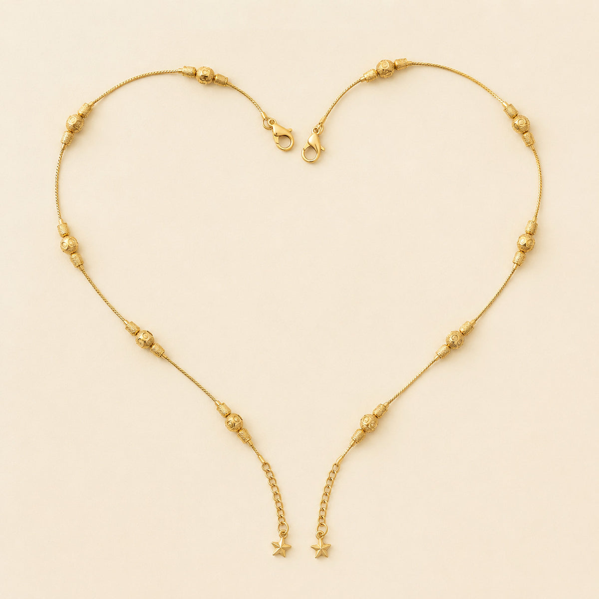 Pair of gold-tone beaded anklets laid flat in heart shape