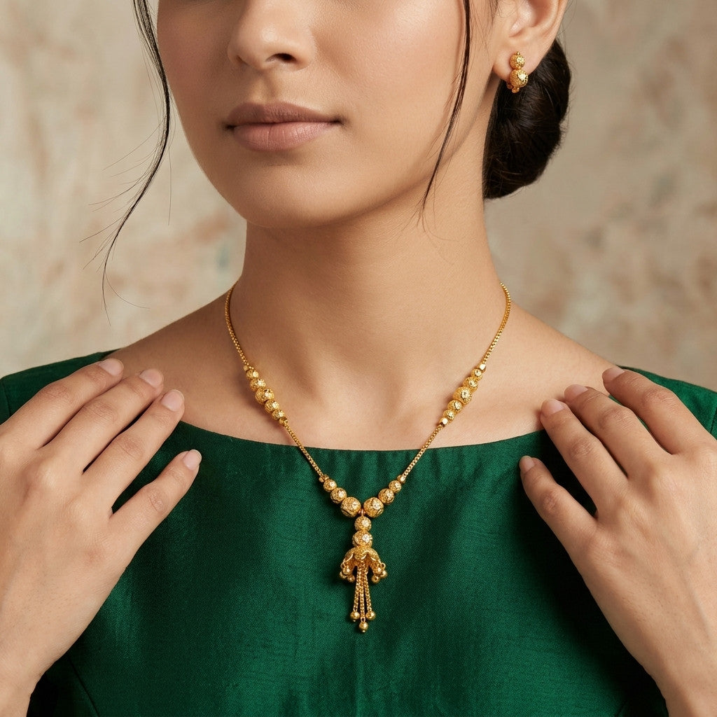 Model wearing gold-tone beaded tassel necklace with matching earrings