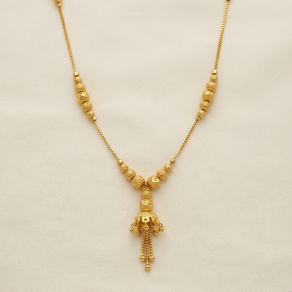 Model wearing gold-tone beaded tassel necklace with matching earrings