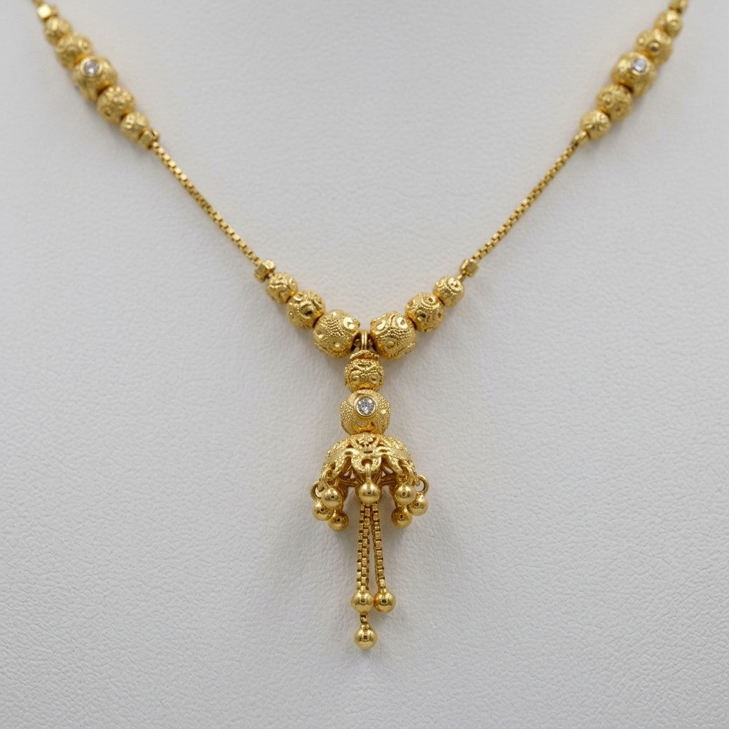 Detail shot of necklace tassel pendant with bead accents on white display
