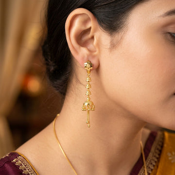 Model wearing gold-tone jhumka style drop earring