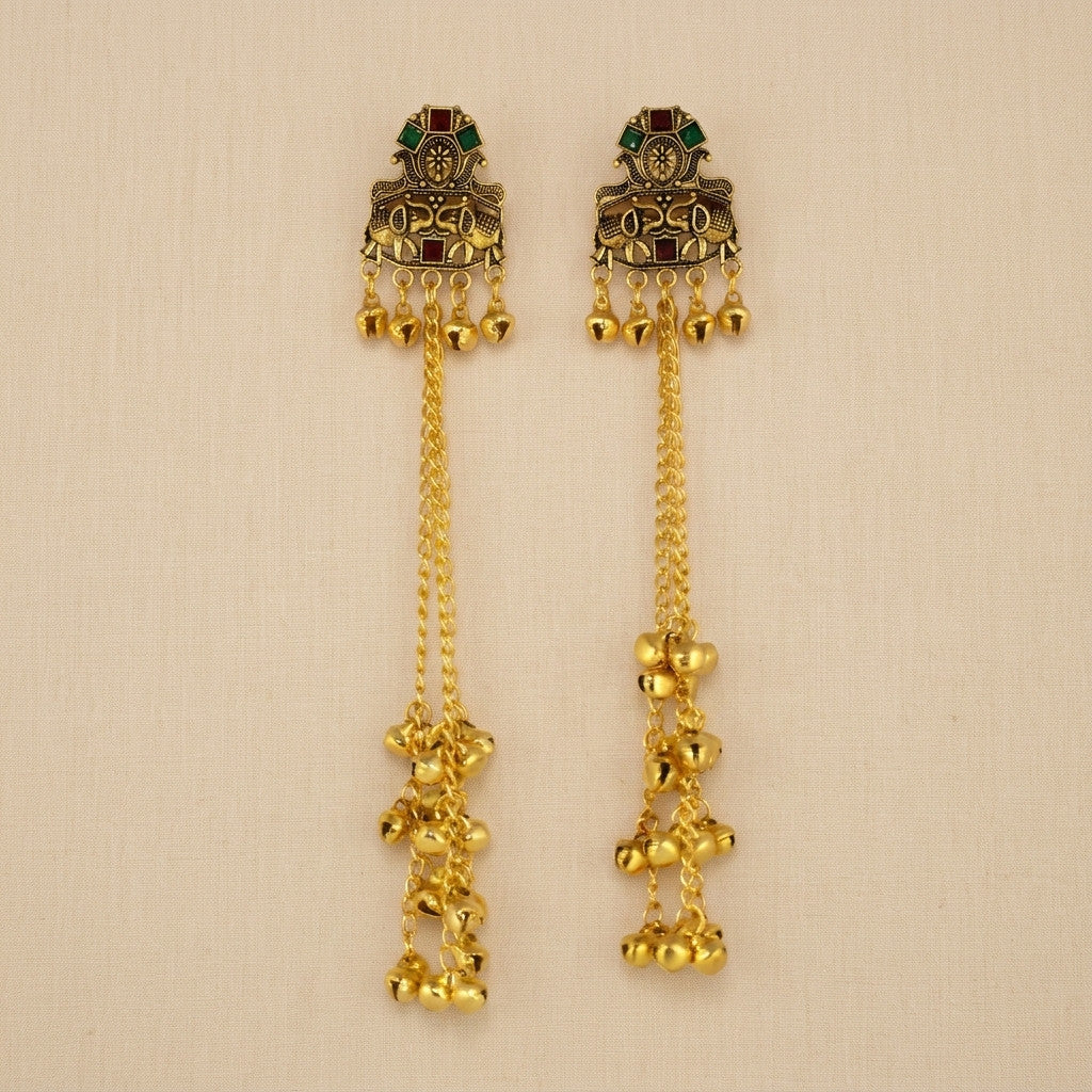 Model wearing gold-tone long chain bell drop earring with green and red accents