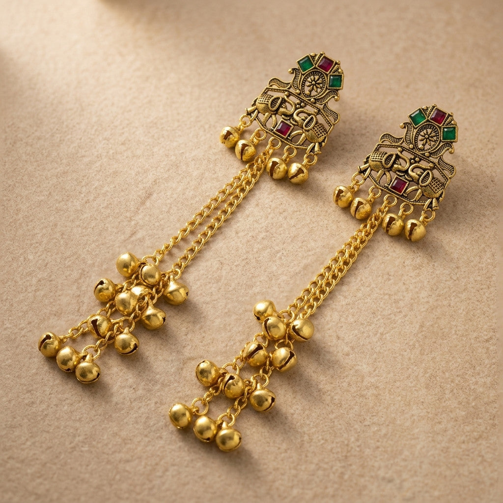 Close-up of gold-tone long chain bell drop earrings showing intricate detailing and hanging bells