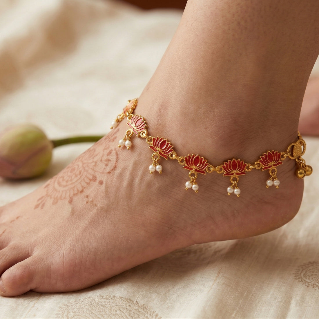 Close-up of foot wearing gold-tone lotus motif red enamel anklet with pearl-look dangles