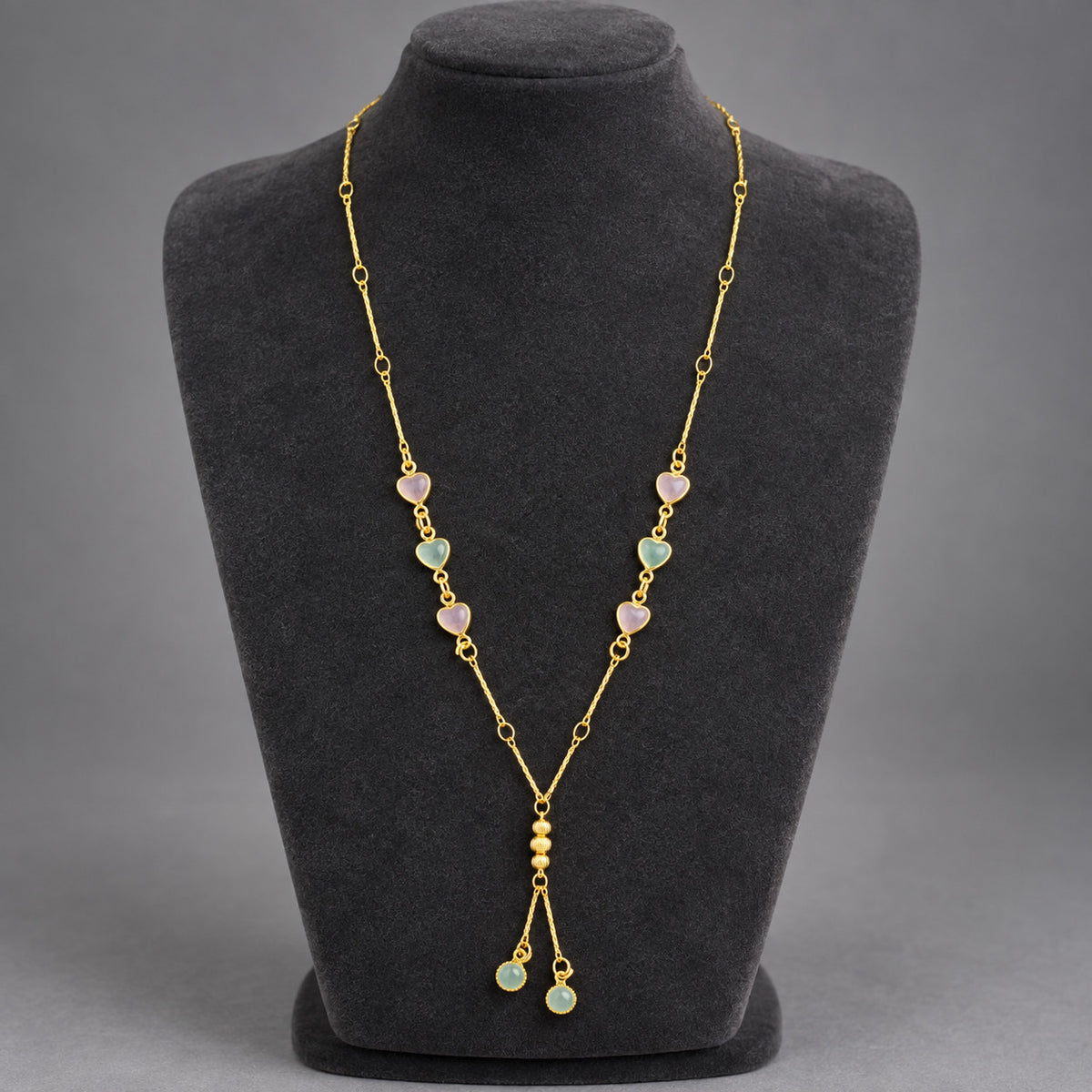 Gold-tone necklace displayed on black mannequin bust