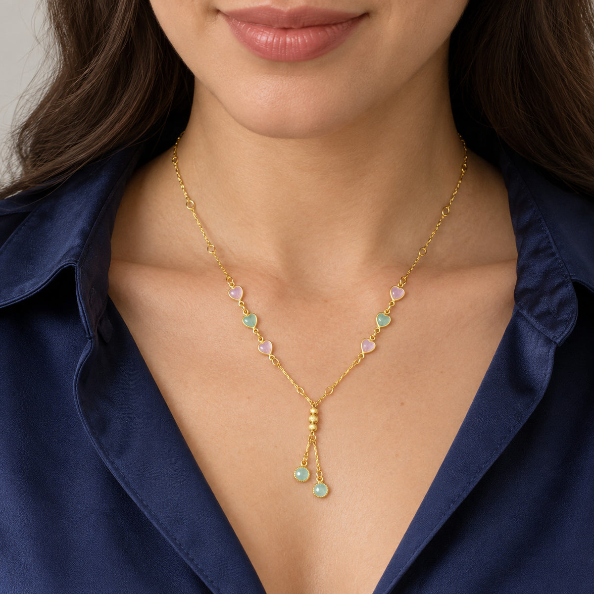 Necklace worn with blue satin top, showing heart accents and drop charms