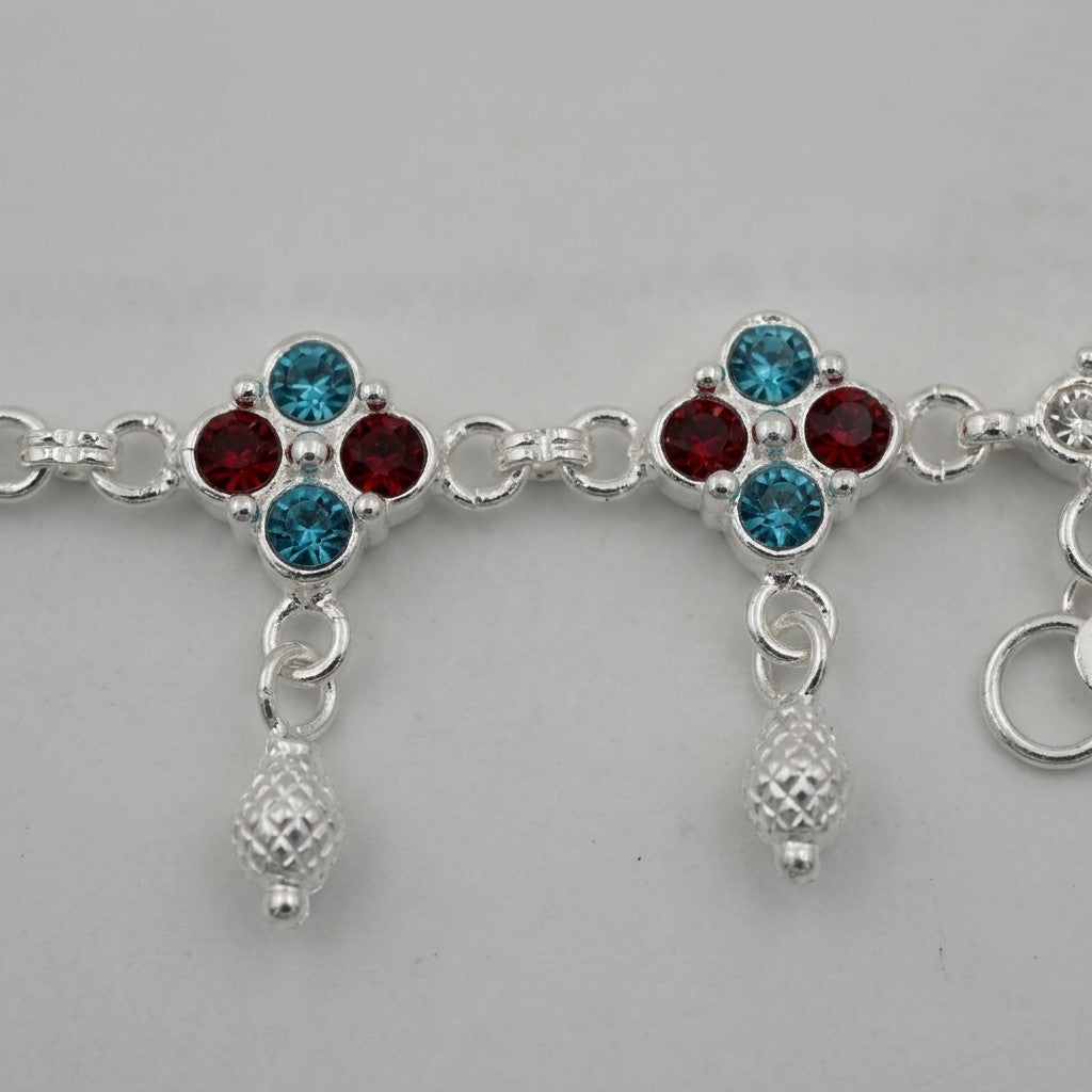 Close-up of floral pattern featuring blue and red stone-look accents with silver-tone dangling charms