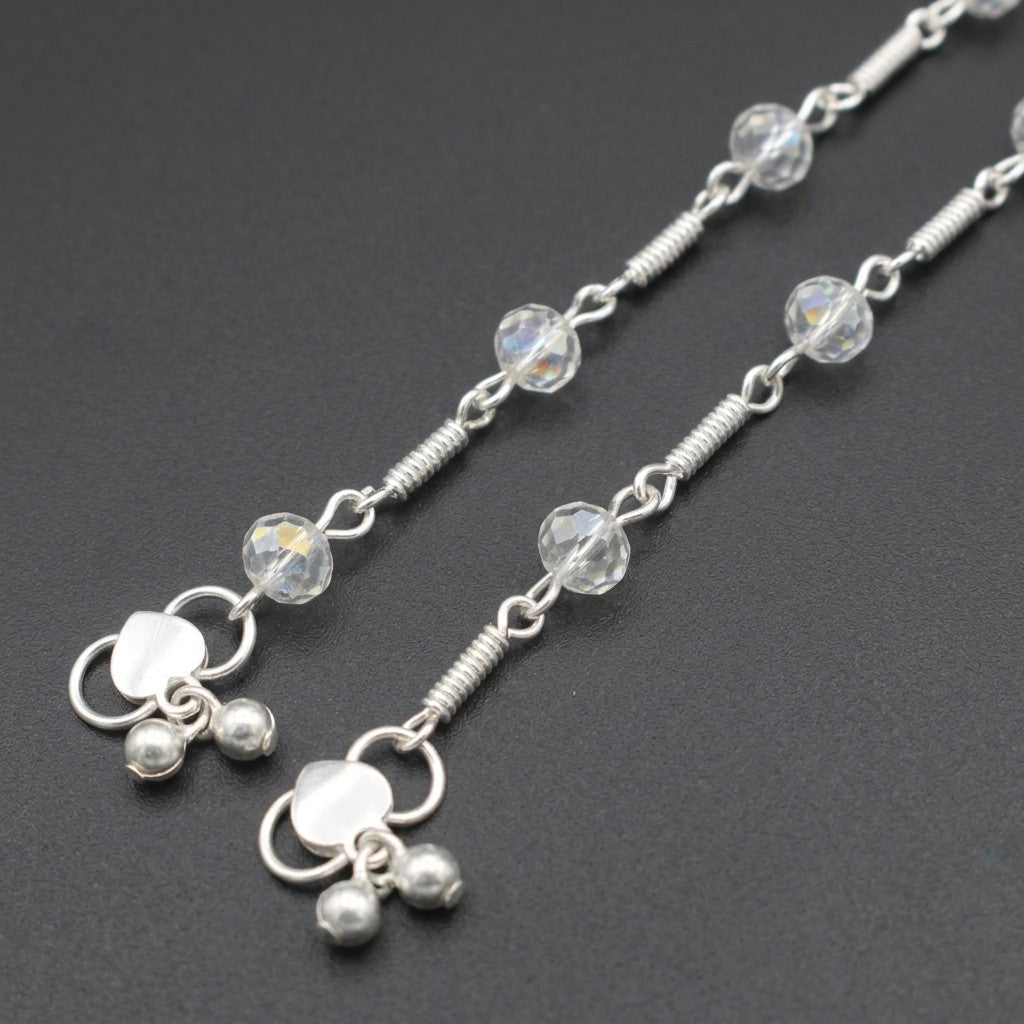 Silver-tone anklet worn on ankle with faceted crystal-look beads