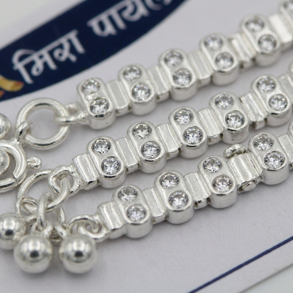 Close-up of silver-tone anklet links showing crystal accents