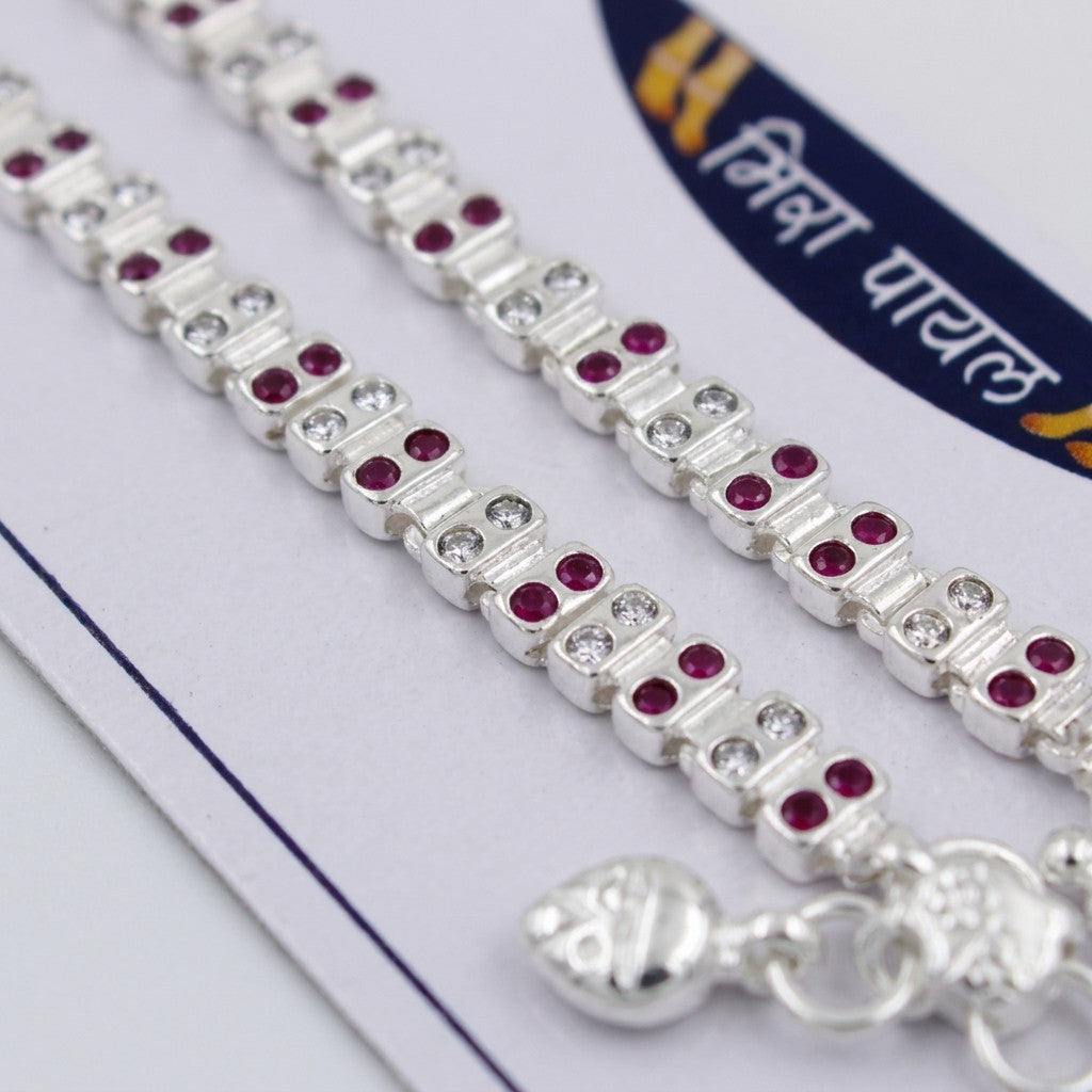 Detailed view of dual-row silver-tone anklet with red and clear stones on branded card