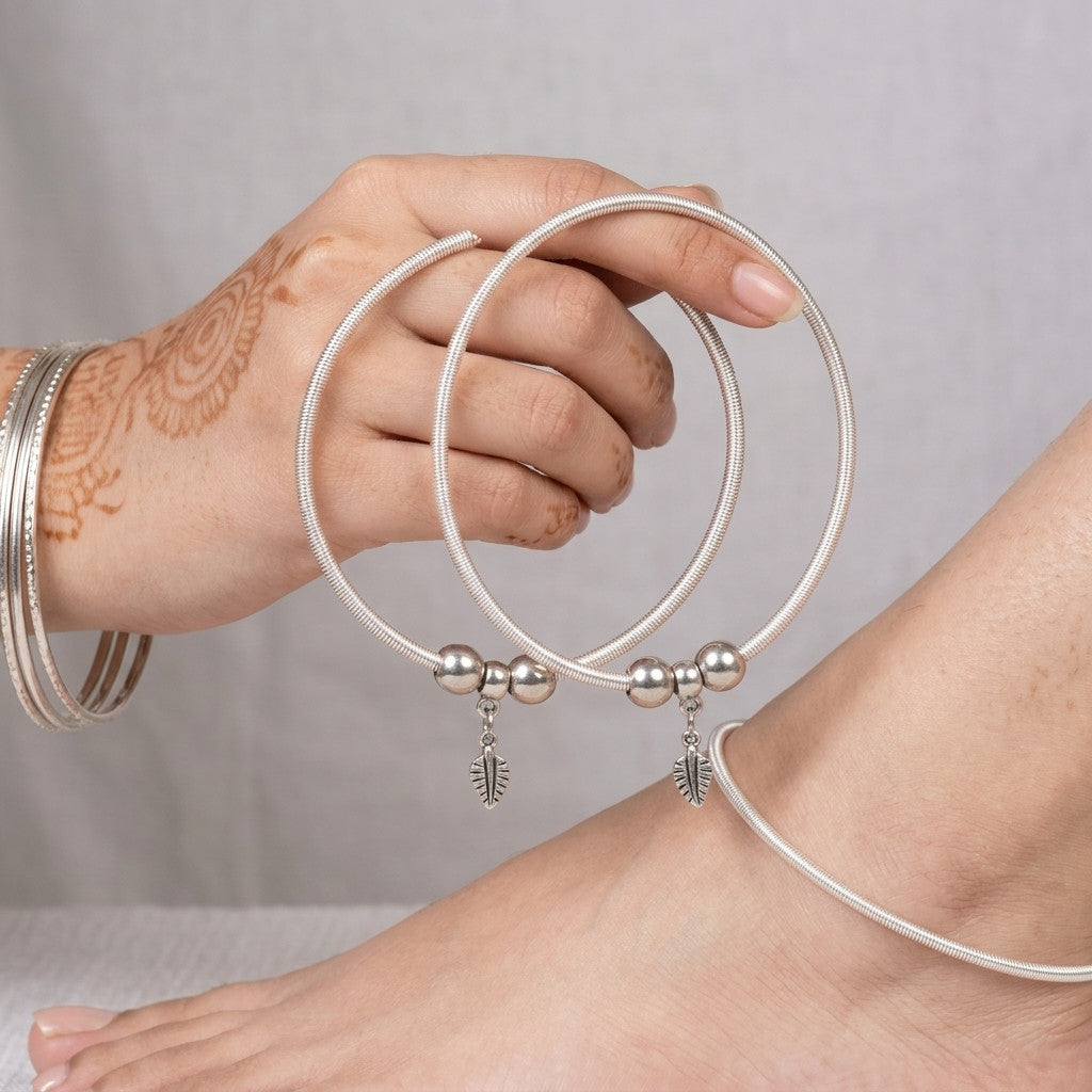 silver-tone leaf charm anklet on ankle